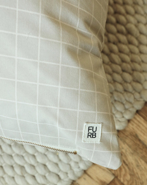 Close-up of Hampton dog bed fabric in tan windowpane pattern, showing plush padding.