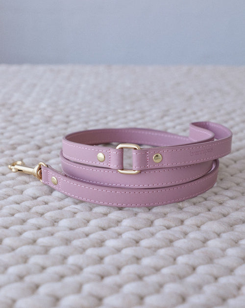 Angled close-up of mauve leather studded dog collar hardware and stitching, highlighting premium materials