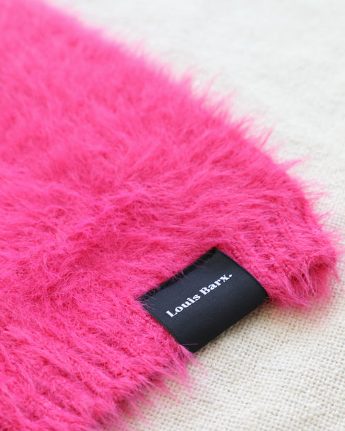 Fluffy hot pink dog sweater on white background, close up of brand tag Louis Barx. Frenchie pink sweater.