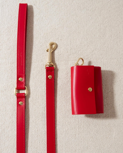 red leather dog poop bag holder with gold accents