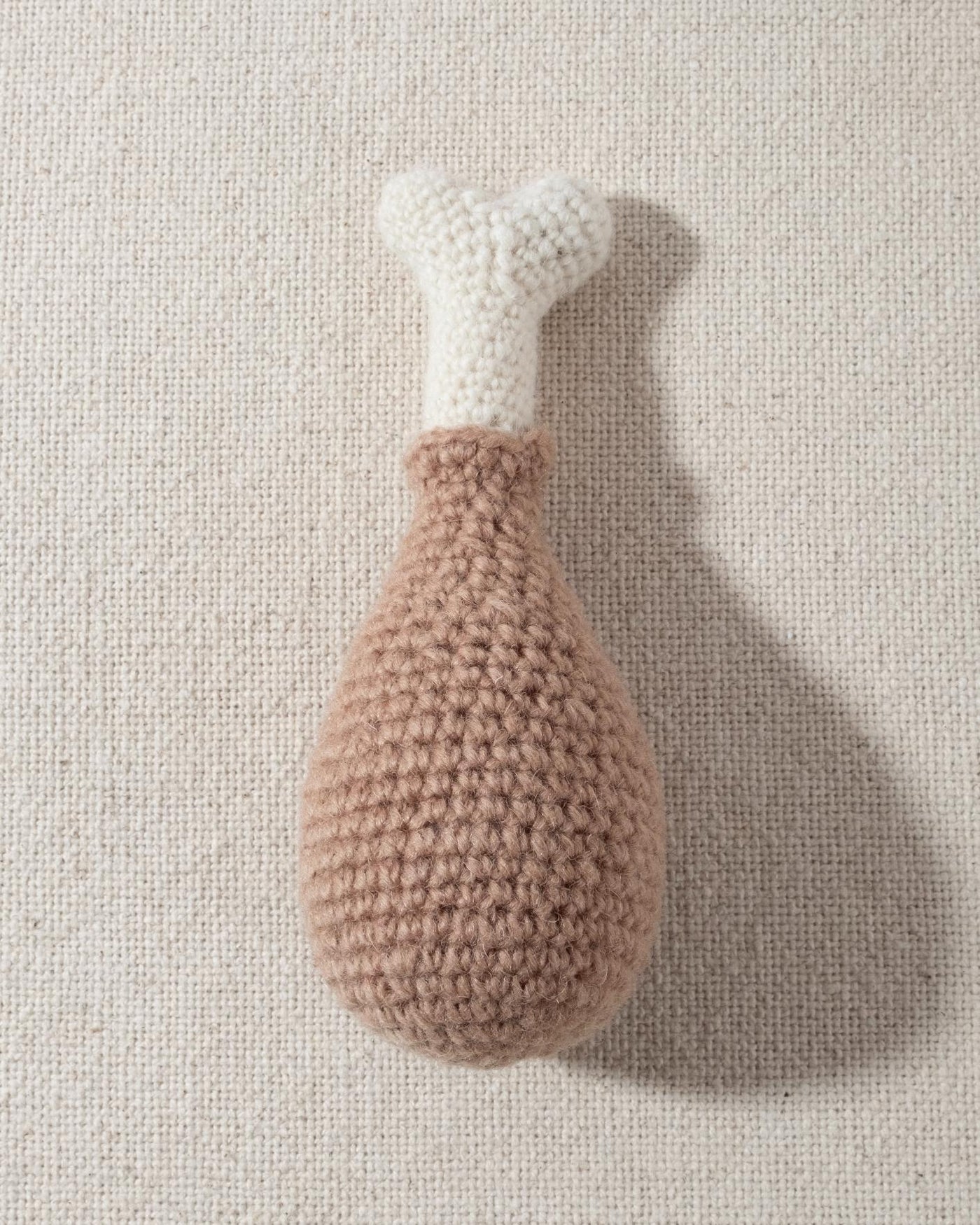 hand knit chicken drumstick dog toy with smiley face