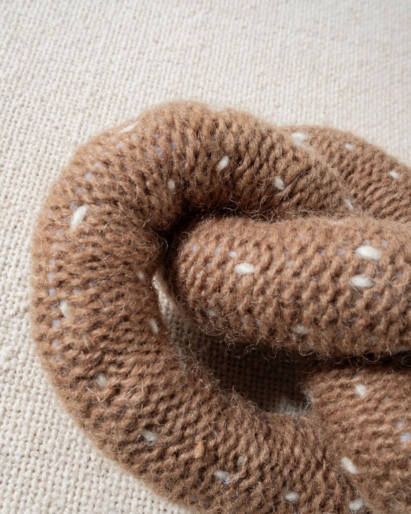 tan and white hand knit crochet pretzel dog toy