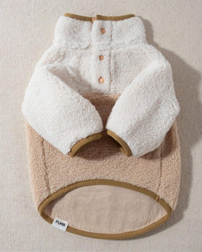 A dreamy tan sherpa bottom half accents a super soft ivory fleece top half, with tan buttons halfway down the placket of this cozy pullover. Tan trim on the cuffs, neck, and bottom hem add the perfect finishing touch for the ultimate street style.