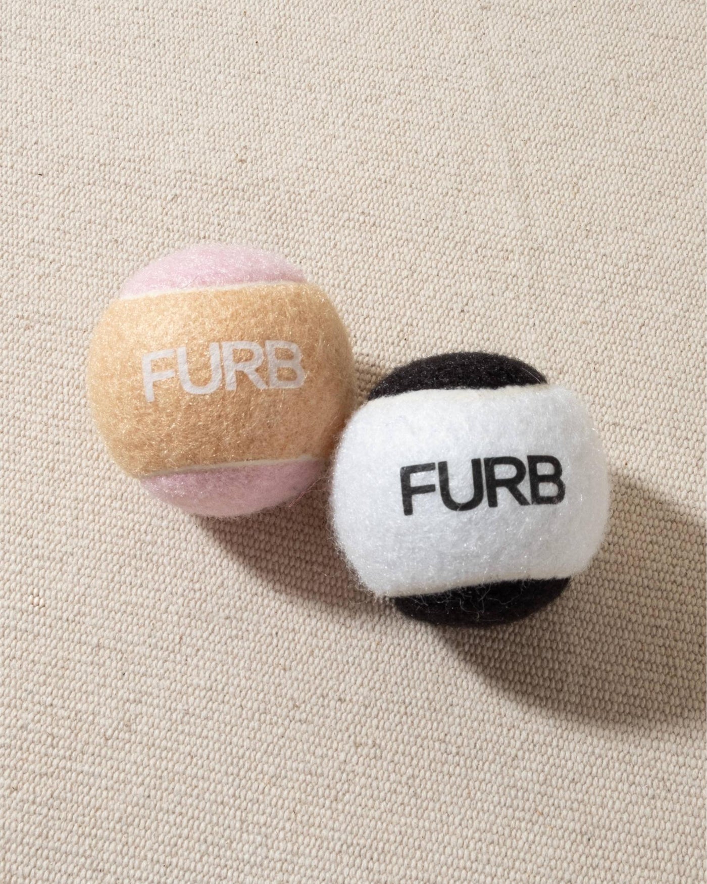 FURB branded black and white tennis ball with black furb logo for dogs