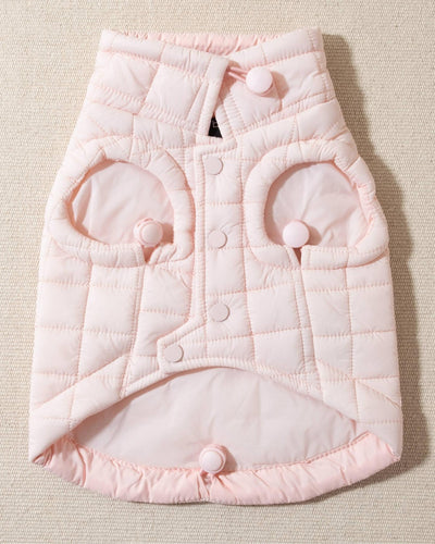 perfect on its own or layered with a cute sweater. This quilted, stylish jacket is fully adjustable, with coordinating light pink cords on the hem, neck, and arm openings. Jacket can be worn over harness, with a small opening for leash attachment on the back. Asymmetrical buttons also make for more secure wear, for even the most portly of pups!