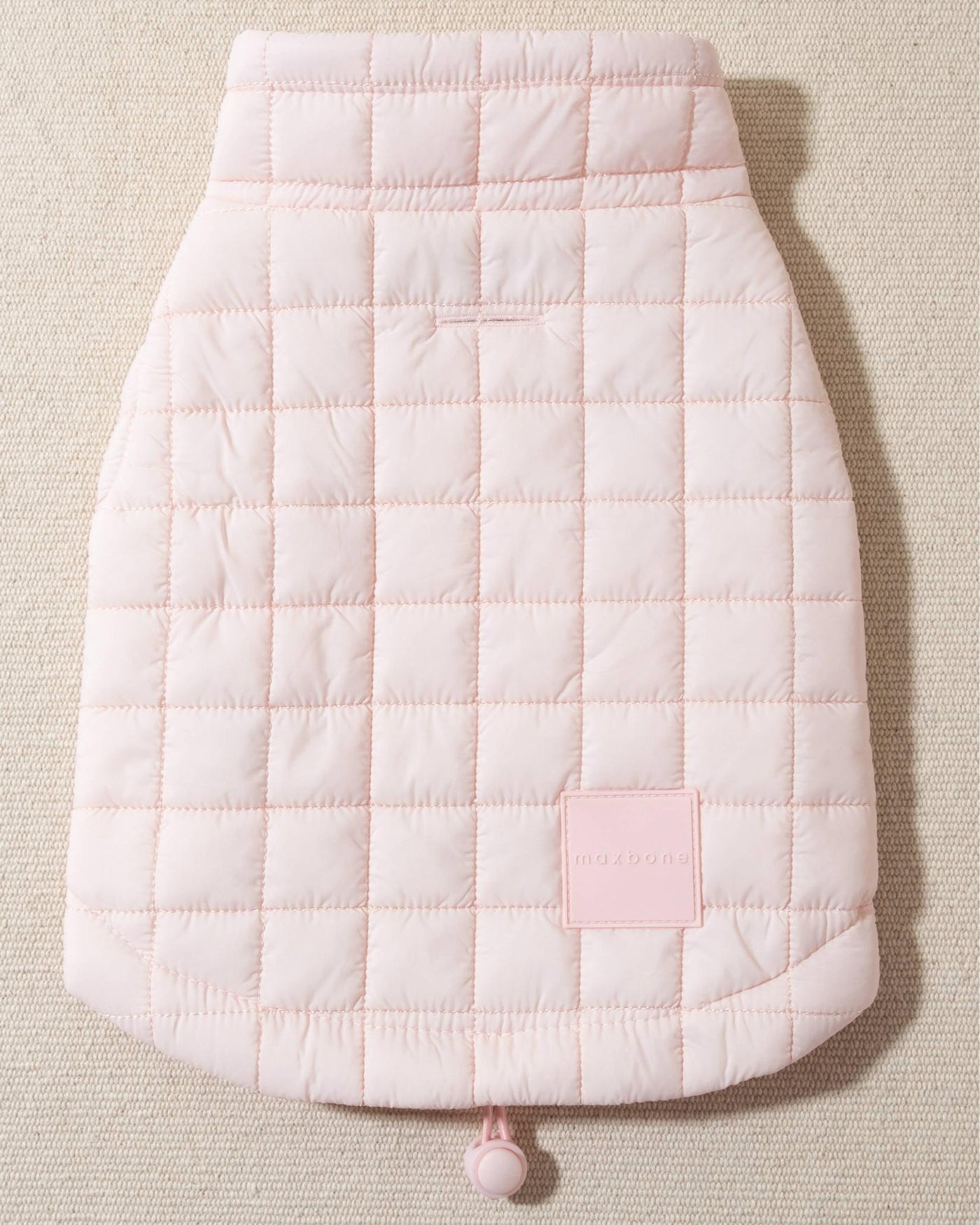 perfect on its own or layered with a cute sweater. This quilted, stylish jacket is fully adjustable, with coordinating light pink cords on the hem, neck, and arm openings. Jacket can be worn over harness, with a small opening for leash attachment on the back. Asymmetrical buttons also make for more secure wear, for even the most portly of pups!