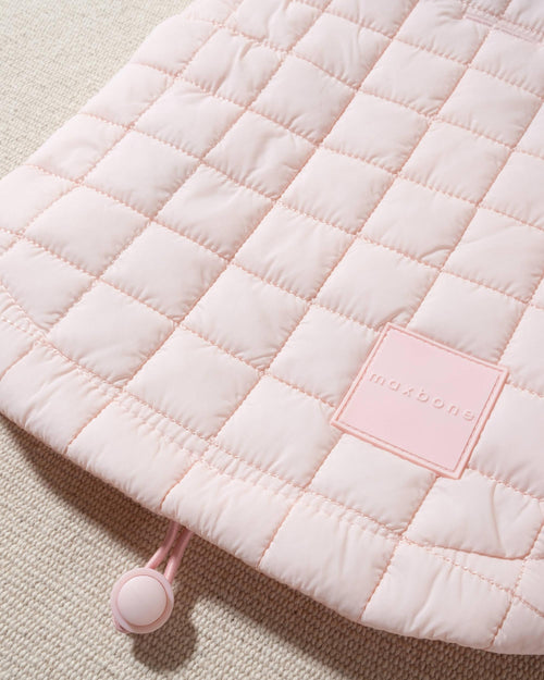 perfect on its own or layered with a cute sweater. This quilted, stylish jacket is fully adjustable, with coordinating light pink cords on the hem, neck, and arm openings. Jacket can be worn over harness, with a small opening for leash attachment on the back. Asymmetrical buttons also make for more secure wear, for even the most portly of pups!. Bichon pink jacket.