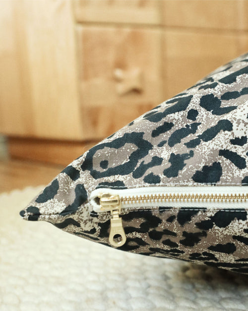 Small dog lounging in stylish leopard print Sarabi bed, highlighting soft fabric and cozy design.