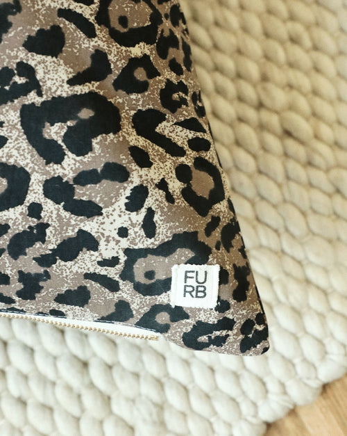 Detailed close-up of plush leopard print dog bed showing texture and stitching quality.