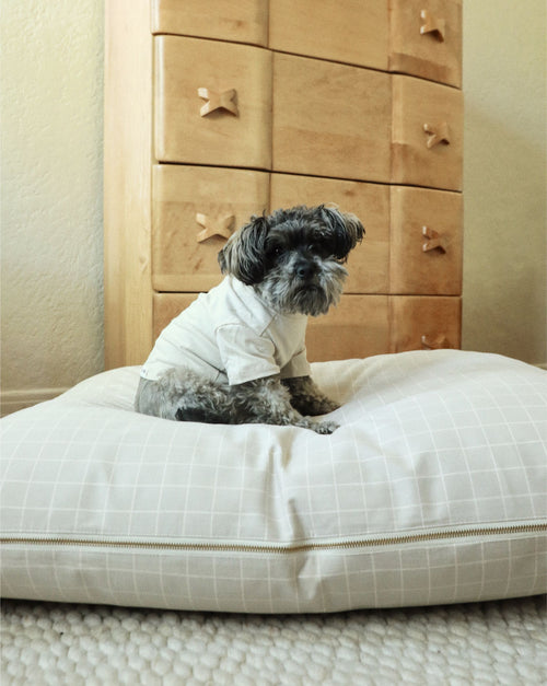 Elegant tan windowpane dog bed with soft cushioning for stylish pet lounging.