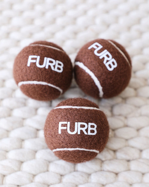 Sturdy brown tennis ball for dogs, ideal for energetic play.
