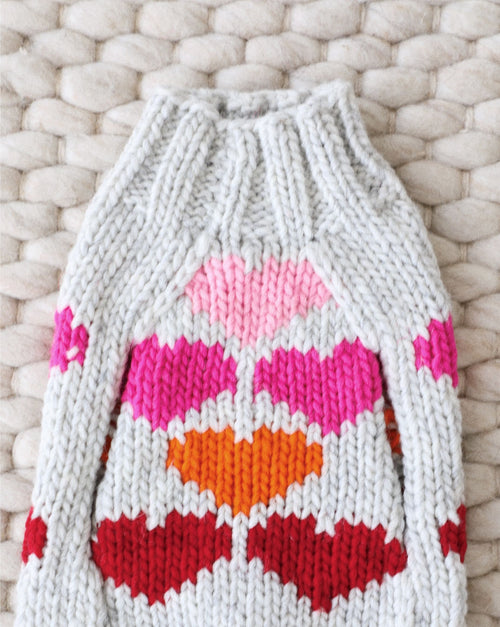 Red knit dog sweater with festive heart design for small breeds.