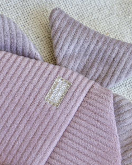 close up of details of purple and pink corduroy fish dog toy with removable plush fish skeleton