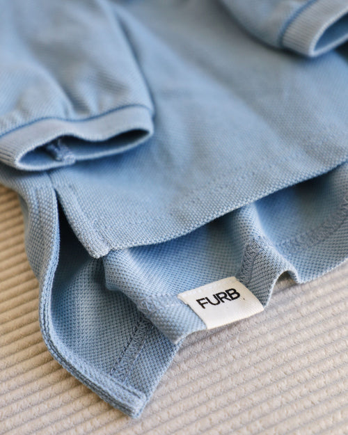 close up shot of FURB tag on baby blue dog polo for pugs
