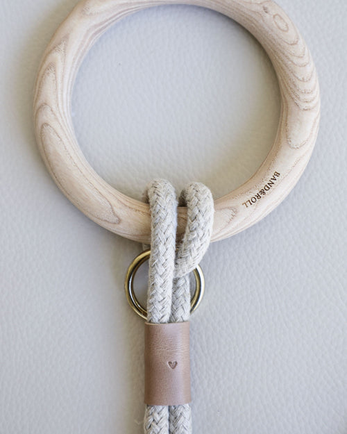 Rope leash connected to round dowel with taupe leather accents and gold hardware