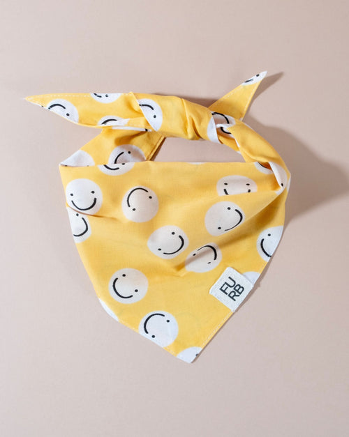 Yellow smiley face bandana for dogs, a cheerful accessory perfect for happy pups.