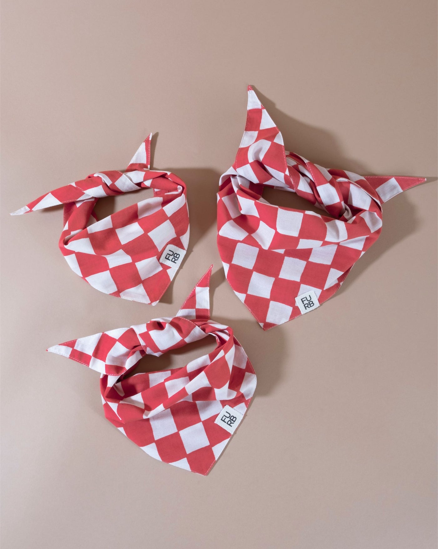 Red checkered dog bandana, a stylish addition for your pet’s wardrobe.