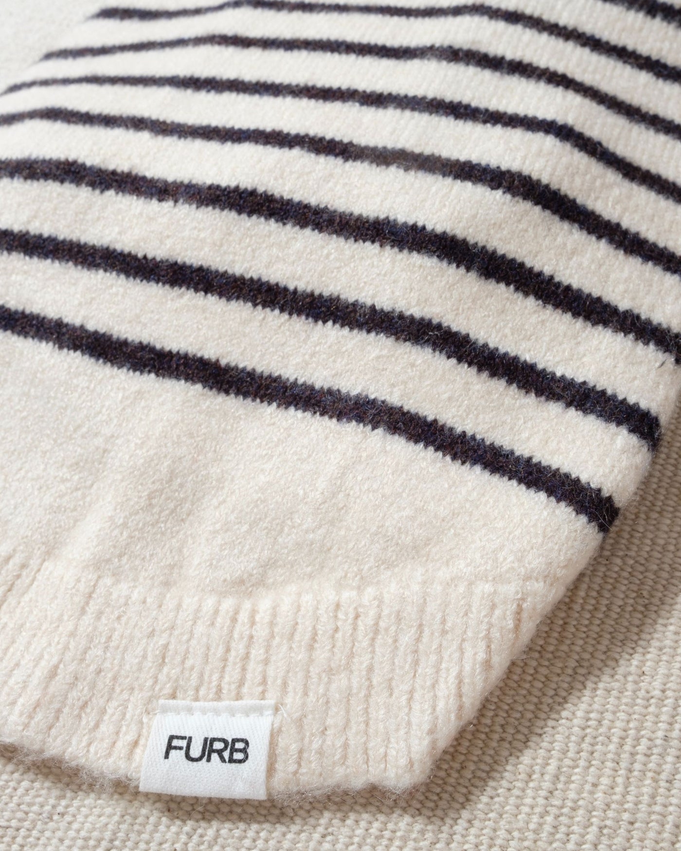 a striped dream, with a comfy ivory knit body covered in thin black stripes, and perfect ribbed ivory turtleneck with coordinating sleeves. The long turtleneck folds over as a toasty touch, and sleeves can be cuffed for a more casual vibe