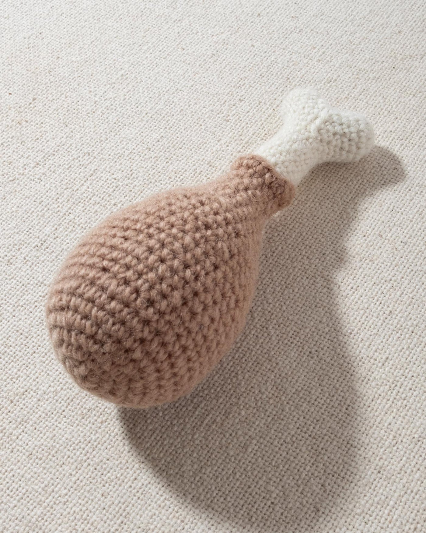 hand knit chicken drumstick dog toy with smiley face