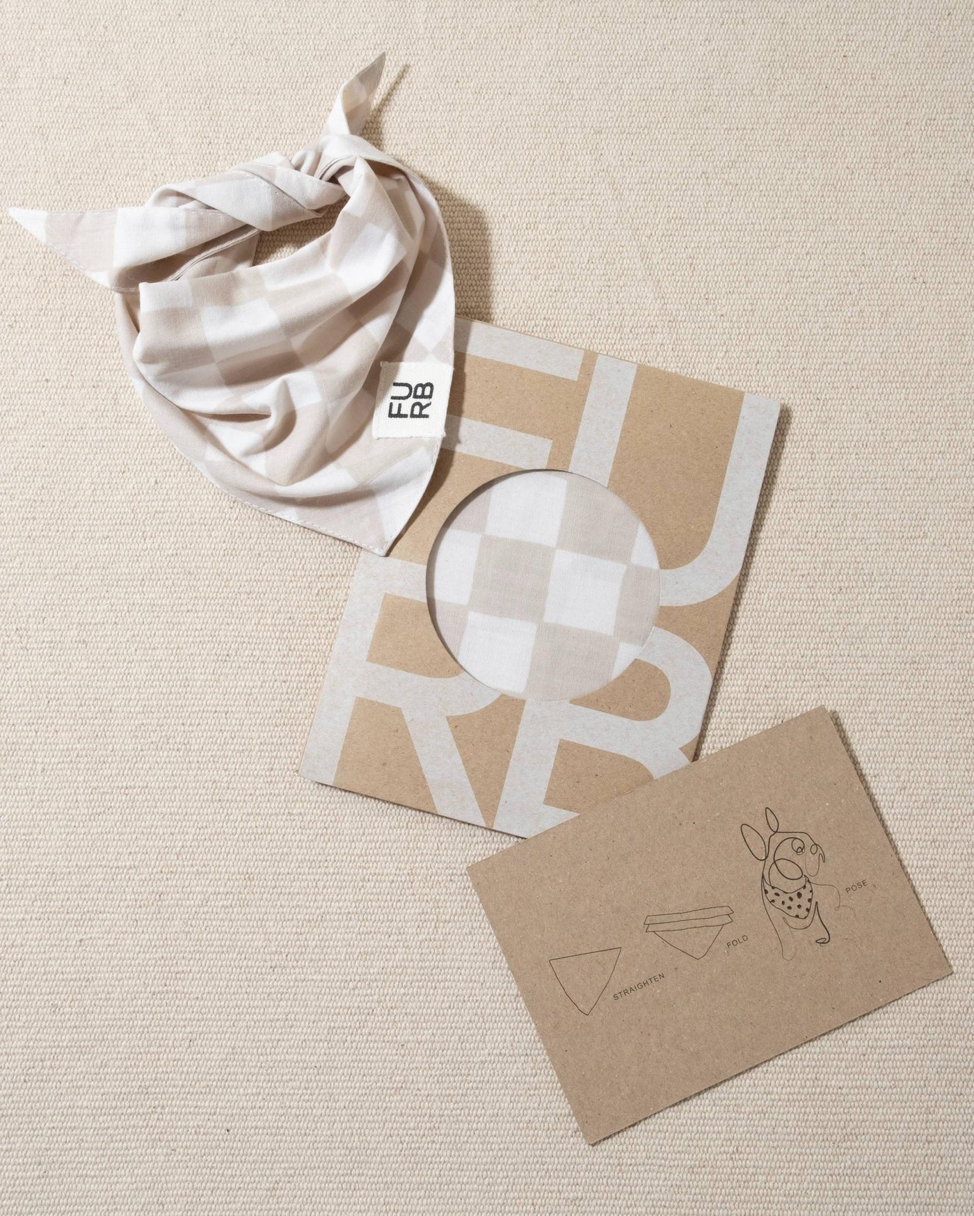 Stylish tan and white check dog bandana with Furb logo, great for adding some fun to your dog’s wardrobe.