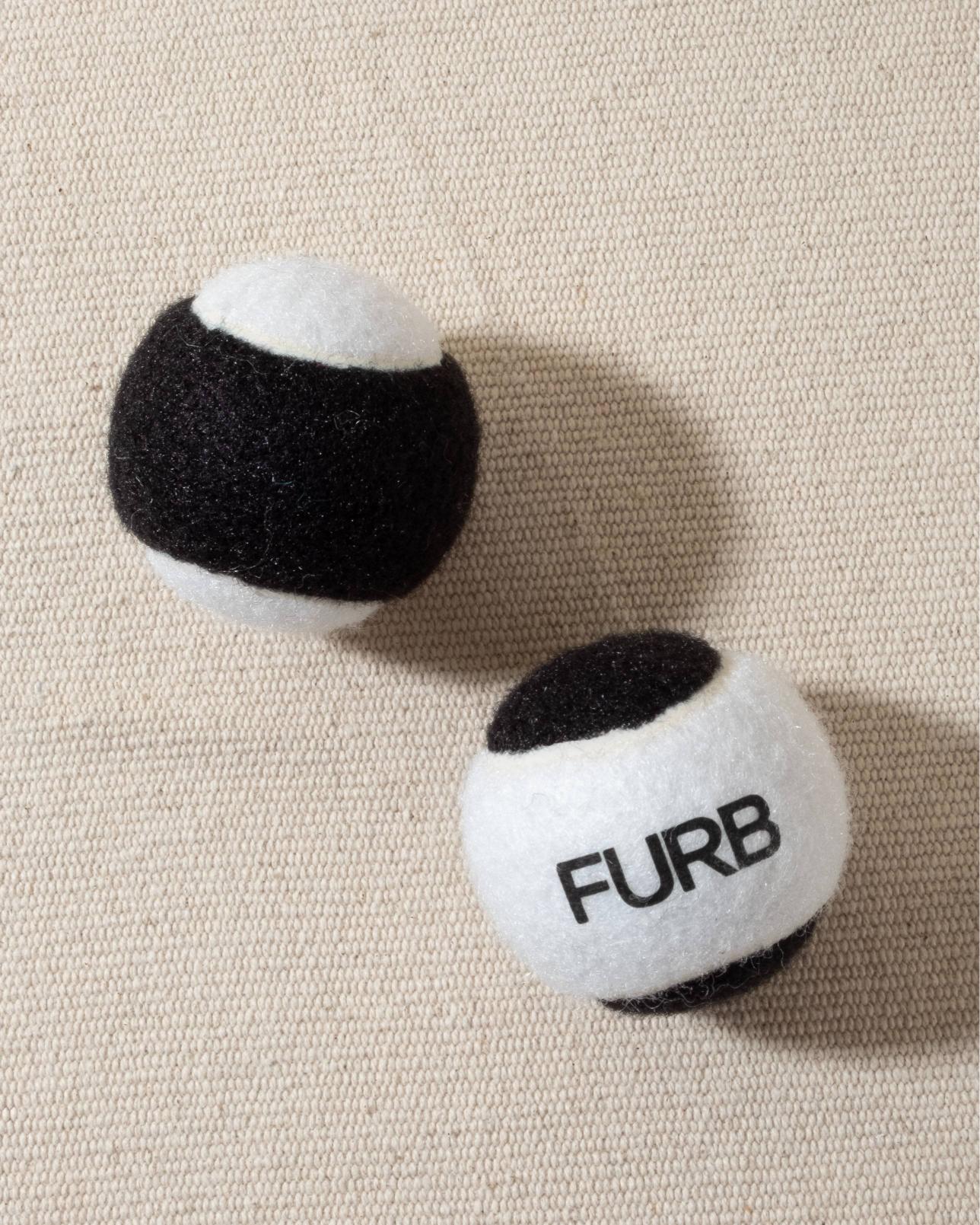 FURB branded black and white tennis ball with black furb logo for dogs