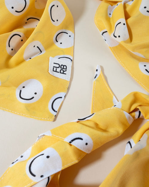 Happy yellow smiley face dog bandana, great for a cheerful pet accessory.