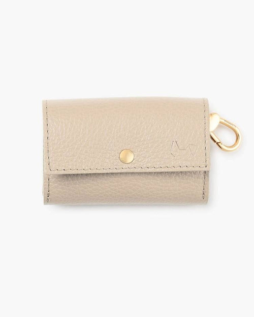 Ivory waste bag holder with gold zipper, designed for stylish dog walks