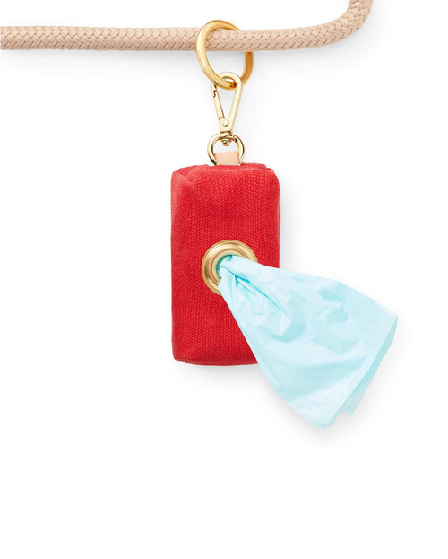 Practical and stylish red dog waste bag holder with brass hardware.