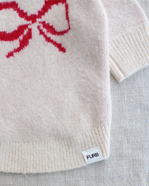 Festive red and ivory dog sweater with adorable bow detail and soft knit construction for small to medium breed dogs