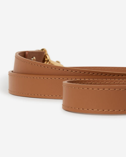 Close-up detail of camel leather dog leash hardware and stitching, emphasizing high-quality materials and secure design